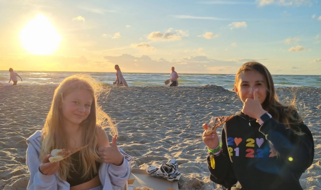 Dziewczyny na plaży na tle zachodzącego słońca