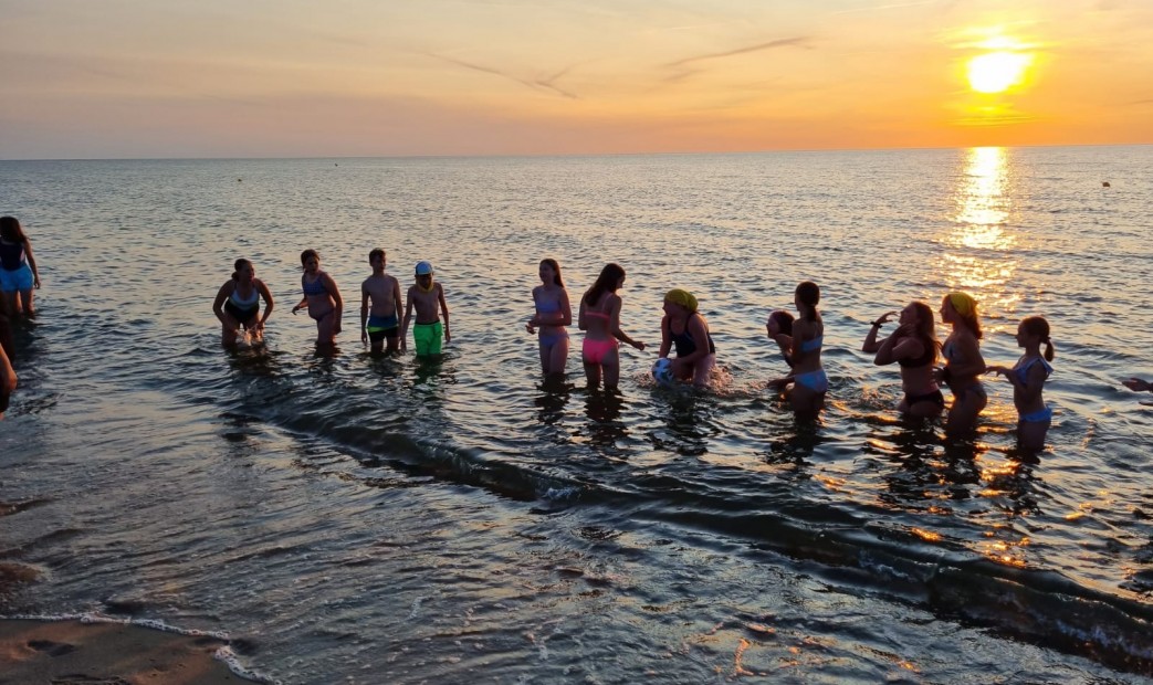 Kąpiel dzieci w morzu o zachodzie słońca