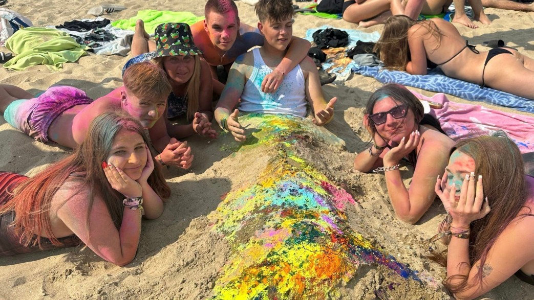 Młodzież na plaży z proszkami holi