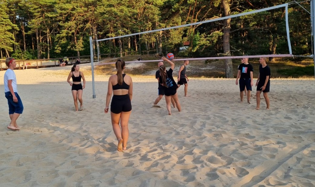 Młodzież grająca w siatkówke plażową