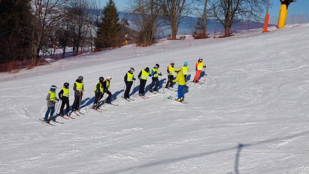 Dzieci uczące się jeździć na nartach